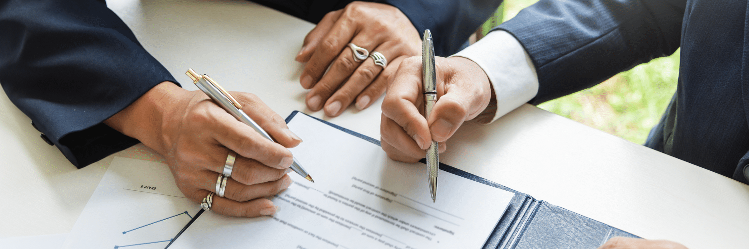 two people signing legal documents